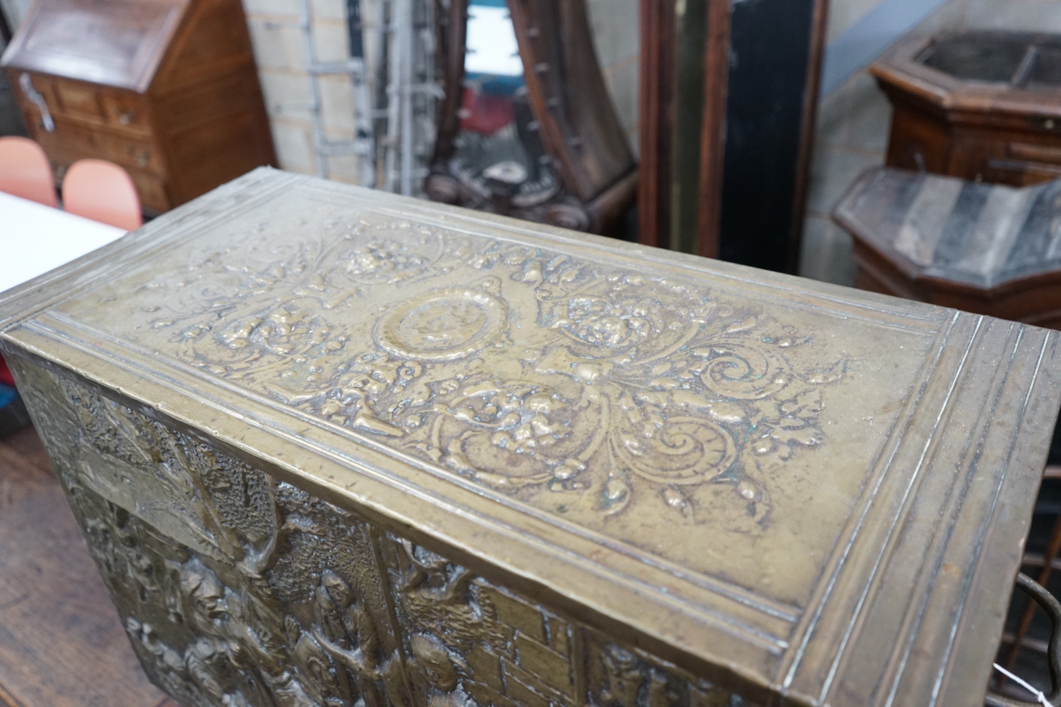 A Dutch style brass repousse log box, width 79cms, depth 35cms, height 57cms.